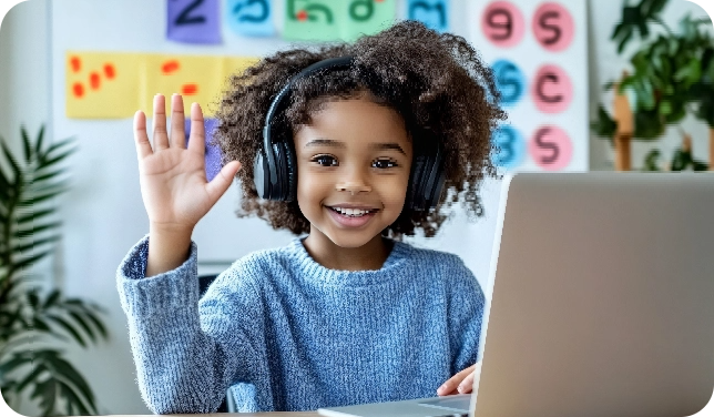 Een kind dat blij lacht en luistert via een koptelefoon en zwaait achter een laptop.